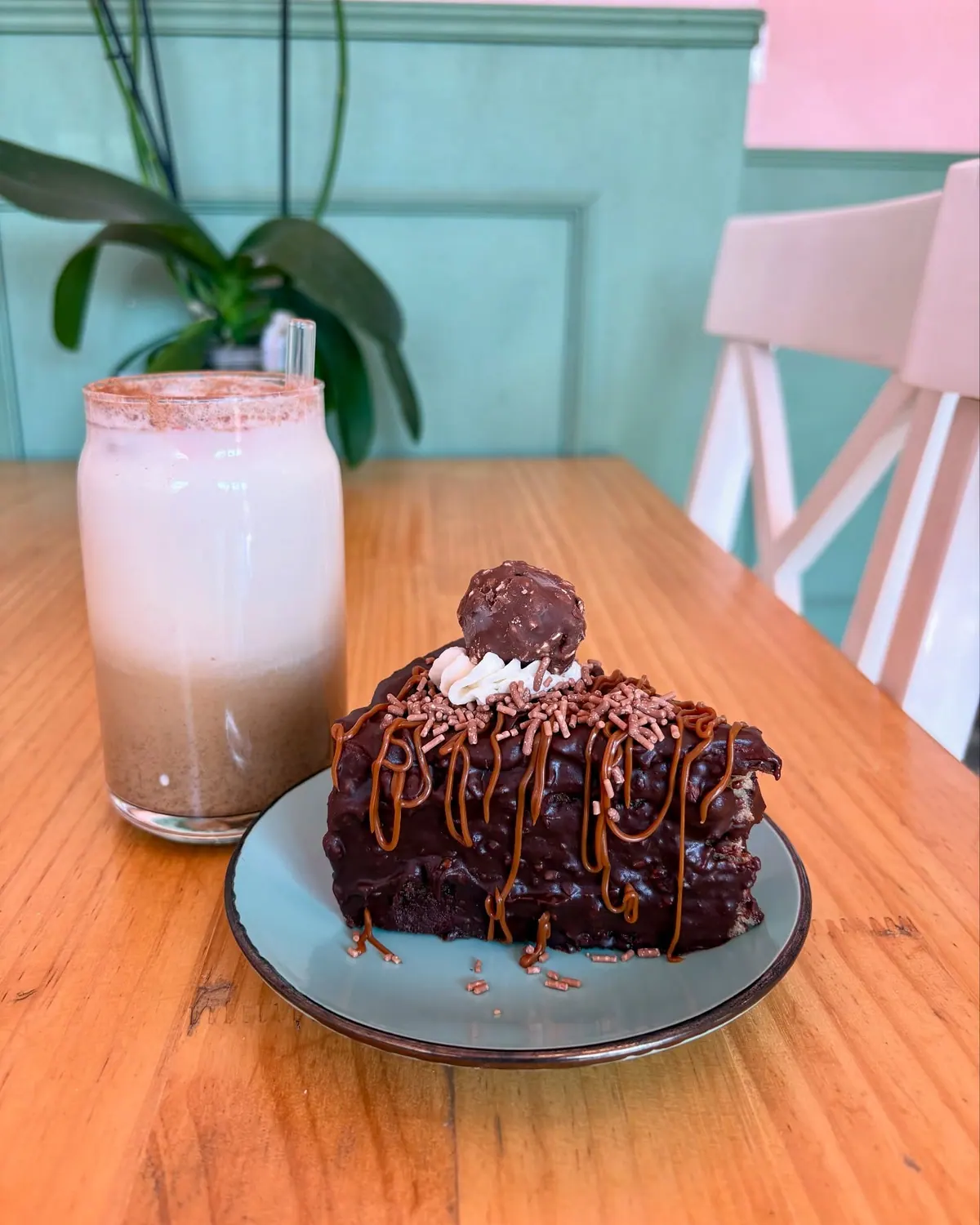 Rebanada de pastel de chocolate y malteada servidas en la mesa del local