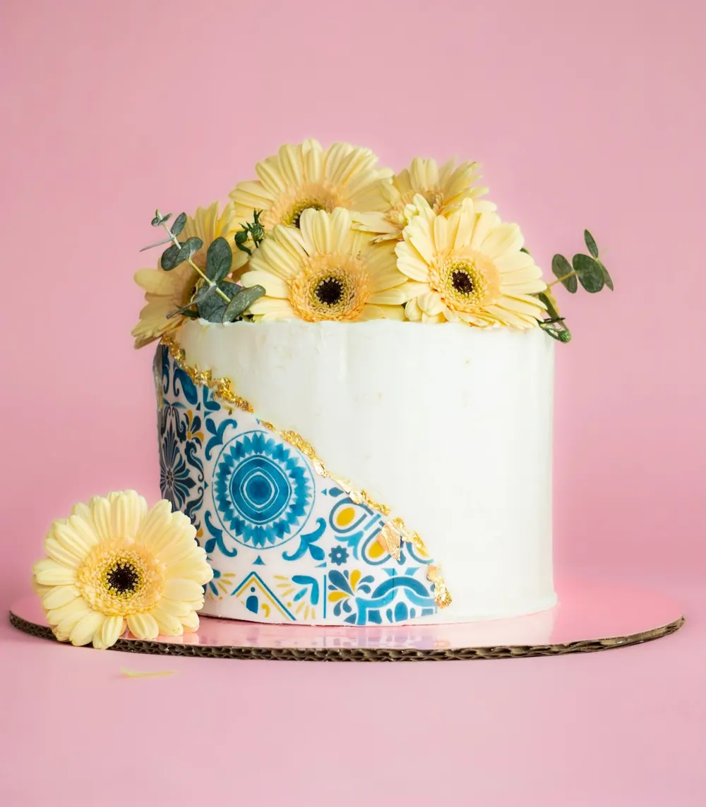 Pastel de buttercream blanco coronado con girasoles